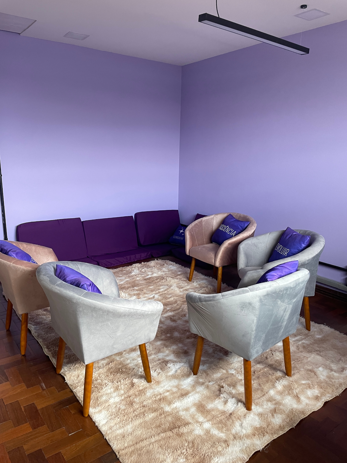 Sala da Elementar Coworking de Saúde com poltronas e almofadas roxas